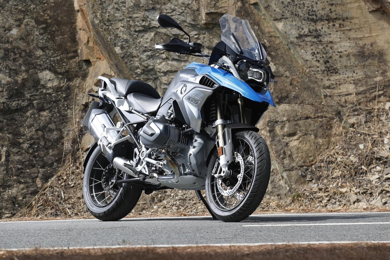BMW R 1250 GS LHS against rock wall on road