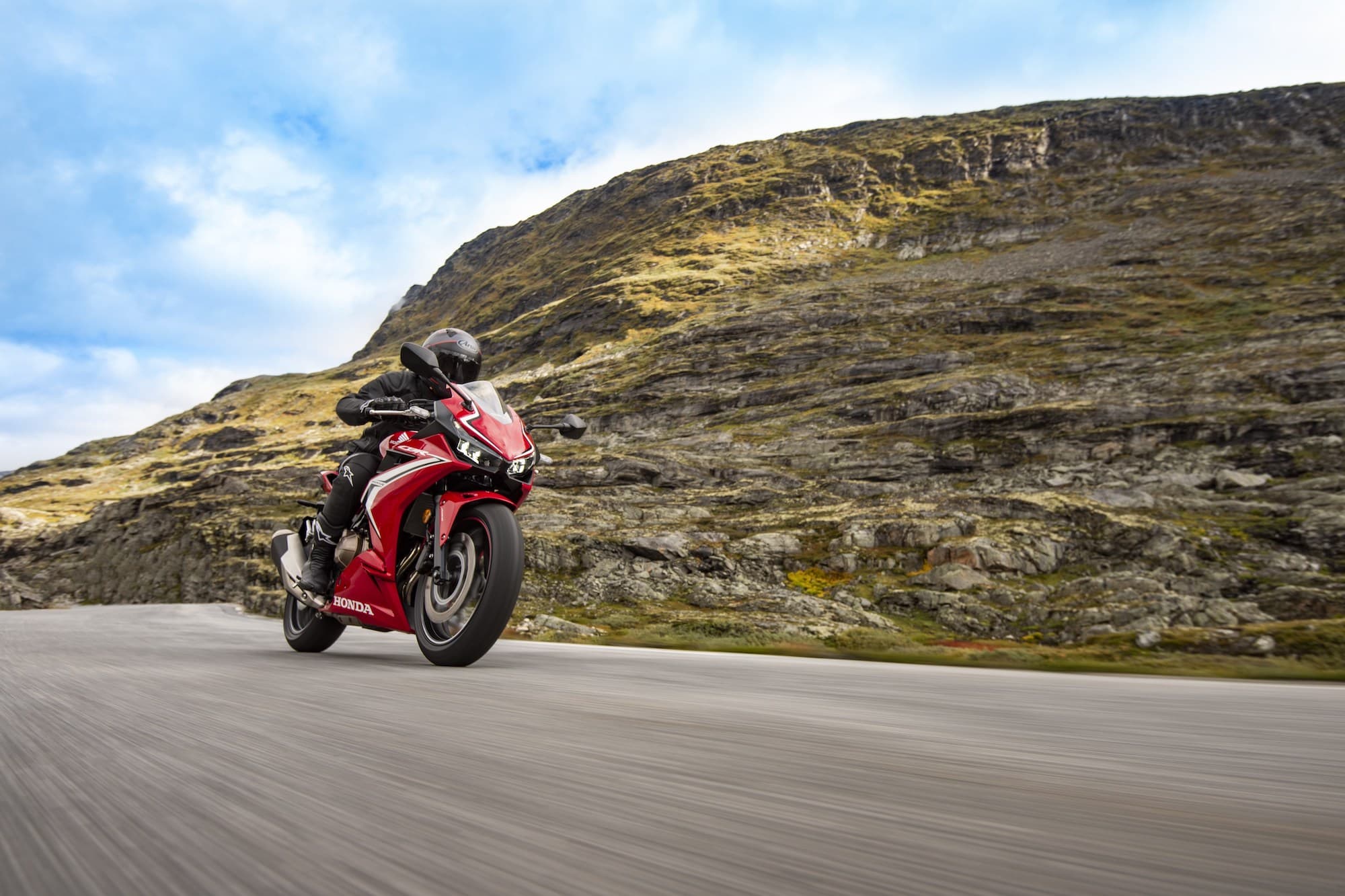2019-2021 Honda CBR500R riding on road with mountain and sky in background