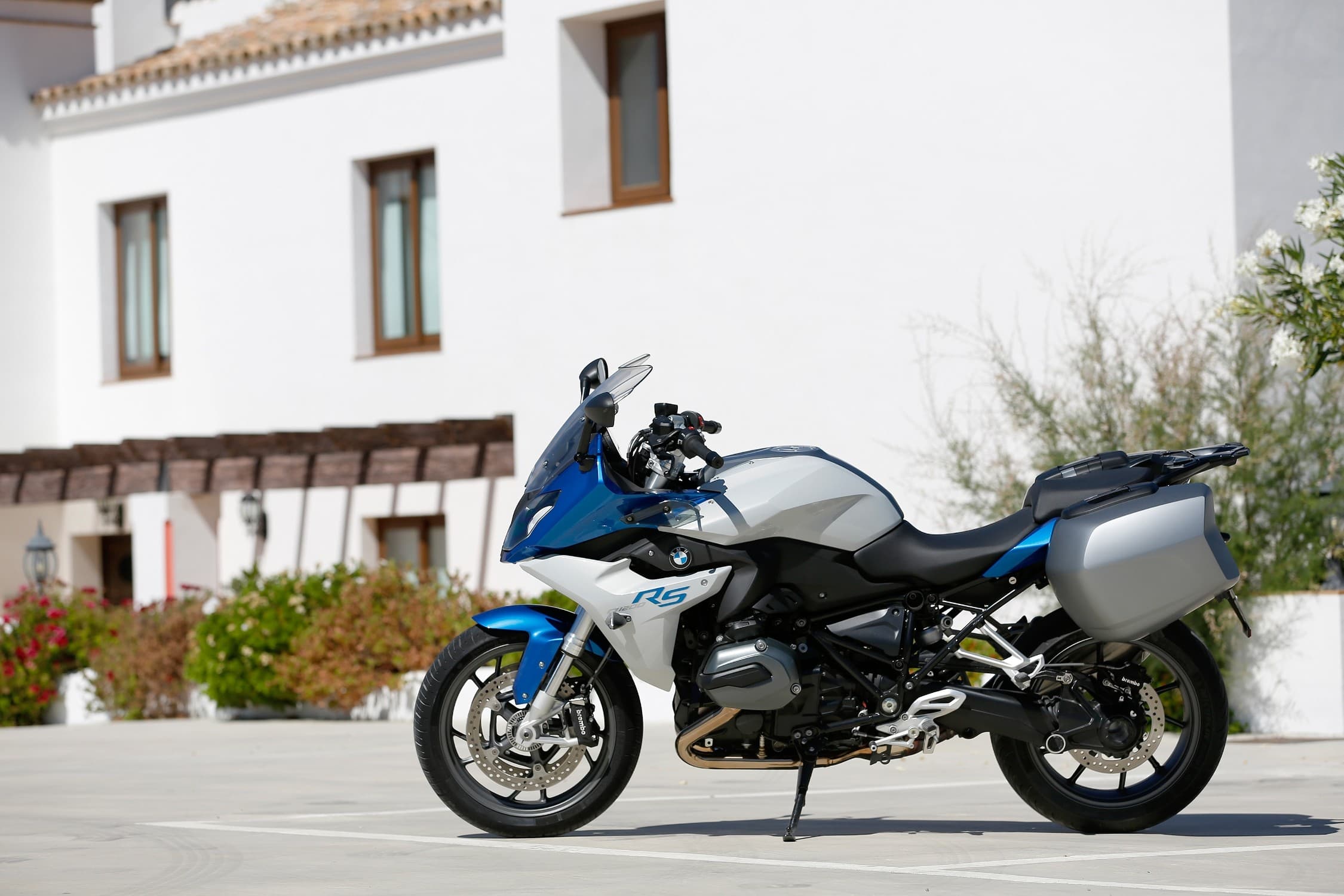 BMW R 1200 RS outdoors on kickstand by white building