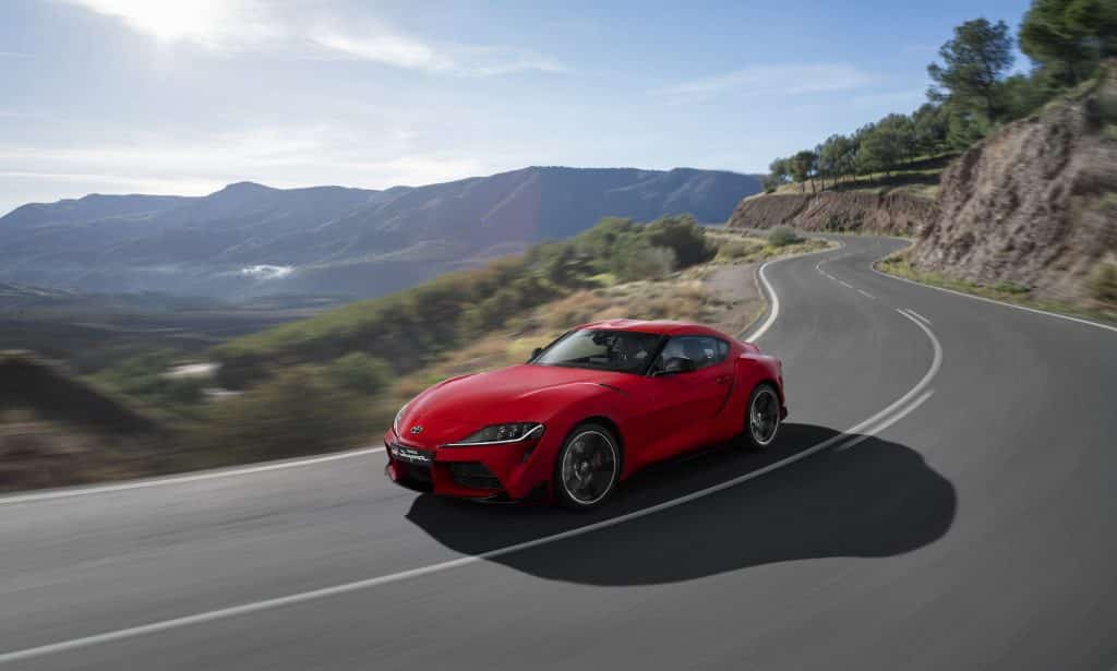 Toyota GR Supra red driving on mountain road