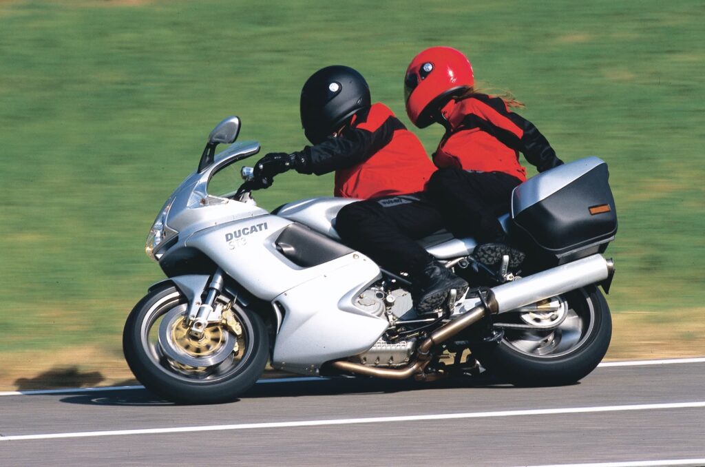 Silver Ducati ST3 LHS riding action with two riders